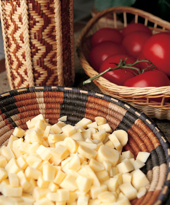 Daugherty uses this African basket daily in the kitchen. A Latvian peeled willow basket holds tomatoes. Daugherty made the tall cobra basket of black ash, Western red cedar bark, and willow.